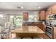 Bright kitchen featuring an island with granite countertops and a sliding glass door to the pool at 1429 E Lowell Ave, Gilbert, AZ 85295