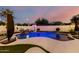 Private backyard pool with a waterfall feature, seating, and lush landscaping at 1429 E Lowell Ave, Gilbert, AZ 85295