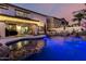 Inviting pool illuminated with lights reflects the home's charming covered patio at 1429 E Lowell Ave, Gilbert, AZ 85295