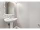 Cozy powder room with a pedestal sink and decorative mirror at 1429 E Lowell Ave, Gilbert, AZ 85295