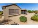 Exterior shot of home, showcasing the screened-in patio and desert landscaping at 15801 W Goldenrod Dr, Surprise, AZ 85374