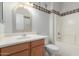Bathroom featuring a decorative sink, toilet and a shower-tub combo at 15801 W Goldenrod Dr, Surprise, AZ 85374