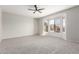 Spacious bedroom featuring neutral tones, carpet, ceiling fan, and a bright bay window at 15801 W Goldenrod Dr, Surprise, AZ 85374