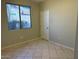 Bedroom featuring tile floors, a window, and a closet door at 15801 W Goldenrod Dr, Surprise, AZ 85374