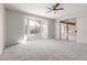 Spacious bedroom with carpet, ceiling fan, bay window, and sliding glass door access to the yard at 15801 W Goldenrod Dr, Surprise, AZ 85374