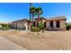 Beautiful single story home with desert landscaping and mature palm trees enhancing the curb appeal at 15801 W Goldenrod Dr, Surprise, AZ 85374