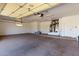 Spacious garage with painted concrete flooring, fluorescent lighting, and a service door at 15801 W Goldenrod Dr, Surprise, AZ 85374