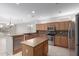 Bright kitchen featuring a center island, breakfast bar, stainless appliances, and wood cabinets at 15801 W Goldenrod Dr, Surprise, AZ 85374