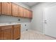 Laundry room with tile floors, cabinets above the counter, a sink, and a door to outside at 15801 W Goldenrod Dr, Surprise, AZ 85374