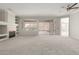 Bright living room boasting plush carpet, built-in shelving, fireplace and natural light from sliding glass door at 15801 W Goldenrod Dr, Surprise, AZ 85374