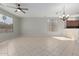 Bright living room featuring tile flooring, a ceiling fan, and large windows, allowing for ample natural light at 15801 W Goldenrod Dr, Surprise, AZ 85374