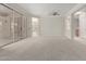 Spacious living room with neutral carpet, ceiling fan, and sliding glass doors to let in plenty of natural light at 15801 W Goldenrod Dr, Surprise, AZ 85374