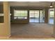 Open living space with neutral carpet, large windows and sliding glass door to the patio at 15801 W Goldenrod Dr, Surprise, AZ 85374