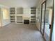 Spacious living room with built-in shelves, fireplace, carpet flooring and sliding door at 15801 W Goldenrod Dr, Surprise, AZ 85374