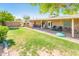 The backyard offers a lush lawn, playhouse, and covered patio for entertaining at 16425 N 46Th Dr, Glendale, AZ 85306