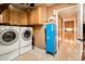 Laundry room featuring washer and dryer, tile floor, and storage cabinets at 16425 N 46Th Dr, Glendale, AZ 85306