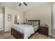 Comfortable bedroom with an adjacent bathroom features a ceiling fan, large bed, and nightstands at 16747 W Berkeley Rd, Goodyear, AZ 85395