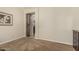 Neutral bedroom showcasing a rustic barn door, painting, and soft carpet at 16747 W Berkeley Rd, Goodyear, AZ 85395