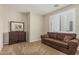 Relaxing bedroom with a sofa, dresser, neutral walls, and plantation shutters for natural light at 16747 W Berkeley Rd, Goodyear, AZ 85395