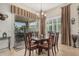 Inviting dining room with modern chandelier, patio access, and large window with plantation shutters at 16747 W Berkeley Rd, Goodyear, AZ 85395
