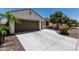 A concrete driveway leads to a well-maintained home with desert landscaping and a spacious three-car garage at 16747 W Berkeley Rd, Goodyear, AZ 85395