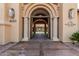 Detailed clubhouse entrance featuring an arched doorway, columns, signage, and exterior lighting at 16747 W Berkeley Rd, Goodyear, AZ 85395