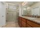 Elegant bathroom featuring double sinks, granite countertop, and glass enclosed shower at 16747 W Berkeley Rd, Goodyear, AZ 85395
