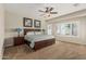 Bright main bedroom with ceiling fan, large window, and neutral carpeting at 16747 W Berkeley Rd, Goodyear, AZ 85395