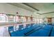 Indoor lap pool featuring multiple lanes, large arched windows, and a checkered tile accent at 16747 W Berkeley Rd, Goodyear, AZ 85395
