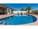 Inviting in-ground pool with steps and lounge chairs surrounded by manicured landscaping on a sunny day at 16747 W Berkeley Rd, Goodyear, AZ 85395
