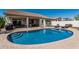 Backyard pool featuring a covered patio with outdoor seating and desert landscaping for relaxation and entertainment at 16747 W Berkeley Rd, Goodyear, AZ 85395