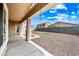 Covered back patio overlooking a low maintenance backyard with a gravel bed and square grass patch at 16763 W Magnolia St, Goodyear, AZ 85338