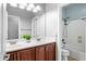 Bathroom with wood cabinet, dual sink and bath/shower at 16763 W Magnolia St, Goodyear, AZ 85338