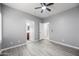 Bedroom with ceiling fan, modern flooring, and entryways to bath and hall at 16763 W Magnolia St, Goodyear, AZ 85338