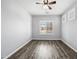 Bedroom with plank floors, modern ceiling fan, and window with plantation shutters at 16763 W Magnolia St, Goodyear, AZ 85338