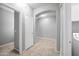 Spacious hallway with tile flooring, neutral paint, and modern lighting fixtures at 16763 W Magnolia St, Goodyear, AZ 85338