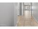 Hallway featuring tile flooring, neutral paint, and an arched entryway in an open floor plan at 16763 W Magnolia St, Goodyear, AZ 85338