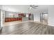 Open-concept living area featuring a view of the modern kitchen with stainless steel appliances and wood cabinets at 16763 W Magnolia St, Goodyear, AZ 85338