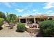 Beautiful backyard featuring a covered patio, cozy firepit, and lush landscaping, perfect for outdoor living at 17630 N Somerset Dr, Surprise, AZ 85374