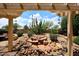 Desert backyard featuring a covered patio, an outdoor firepit, and natural landscaping, perfect for outdoor entertaining at 17630 N Somerset Dr, Surprise, AZ 85374