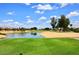 Picturesque golf course with sand traps, a tranquil pond, and well-manicured green grass at 17630 N Somerset Dr, Surprise, AZ 85374
