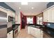Well-lit kitchen with white cabinetry, granite countertops, and stainless steel appliances at 17630 N Somerset Dr, Surprise, AZ 85374