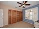 Office space featuring built-in bookshelves, natural light, ceiling fan and plush carpeting at 17630 N Somerset Dr, Surprise, AZ 85374
