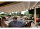Relaxing covered patio with stylish outdoor furniture and views of the meticulously landscaped backyard at 17630 N Somerset Dr, Surprise, AZ 85374