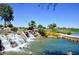 Scenic pond with waterfall feature, lush landscaping and a bridge with golf course backdrop at 17630 N Somerset Dr, Surprise, AZ 85374