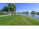 Scenic view of a well-maintained pond with a fountain and picnic tables in a lush community setting at 17630 N Somerset Dr, Surprise, AZ 85374
