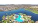 Aerial view of community pool, lounge area, lush landscaping, and lake view at 17900 W Briarwood Dr, Goodyear, AZ 85338