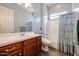 Well-lit bathroom with a shower-tub combo, wood cabinets, and unique colorful privacy glass at 17900 W Briarwood Dr, Goodyear, AZ 85338
