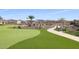Beautiful green space with mature desert landscaping, walking path, bench, and view of residential homes at 17900 W Briarwood Dr, Goodyear, AZ 85338
