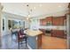 Open concept kitchen featuring a center island, wooden cabinetry, stainless appliances, and adjacent dining area at 17900 W Briarwood Dr, Goodyear, AZ 85338